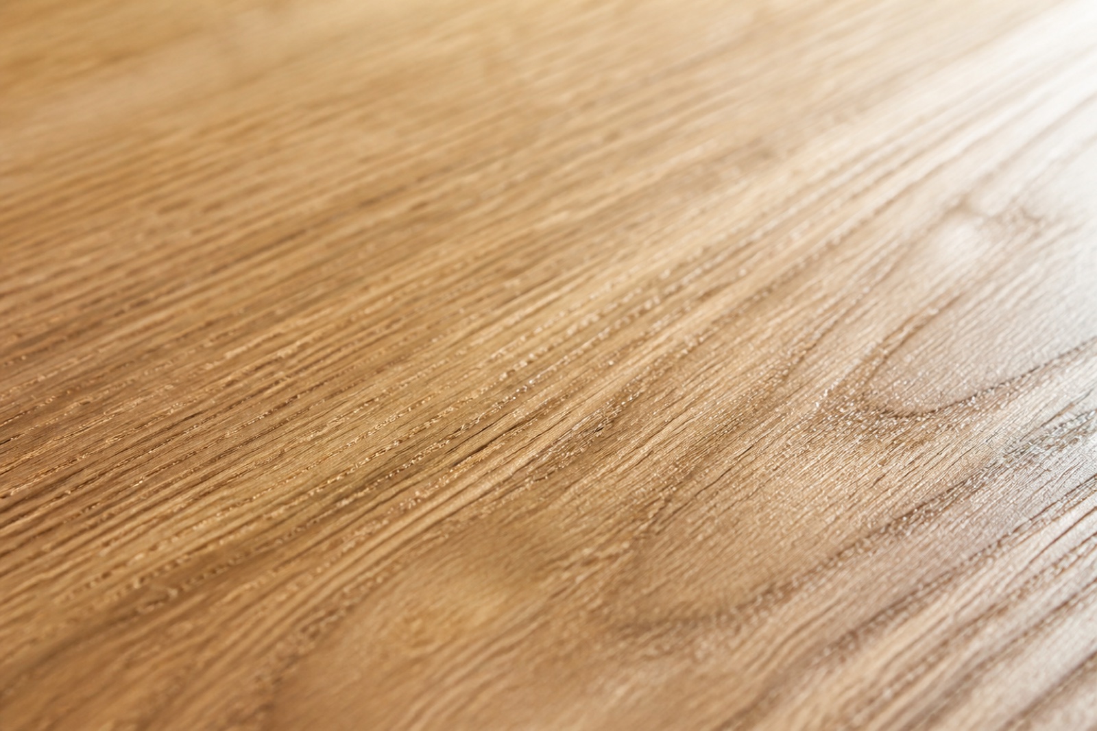 Raked light across the open grain of a planed white oak board